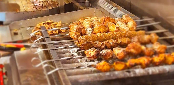 Chicken skewers grilling over charcoal